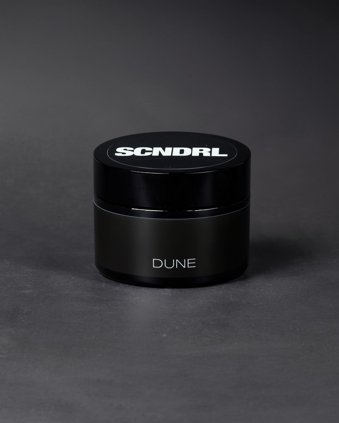 Black container with 'SCNDRL' and 'DUNE' branding on a dark gray background