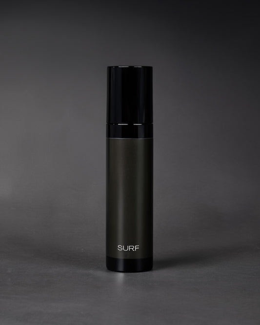 Black cylindrical bottle with 'SURF' branding on a gray background